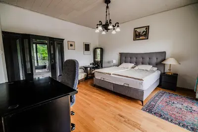 a bedroom with a bed and a table and chairs at Parkside Haven with 4 Bedrooms & free parking in Ljubljana