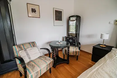 a living room with a table and a chair at Parkside Haven with 4 Bedrooms & free parking in Ljubljana