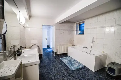 a bathroom with a white tub and a sink at Parkside Haven with 4 Bedrooms & free parking in Ljubljana
