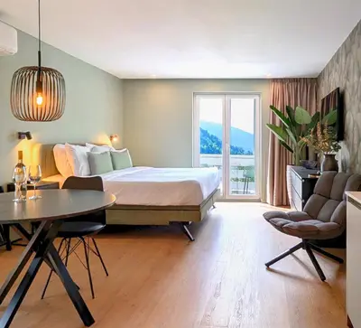 a bedroom with a large bed and a table and chairs at Green Heart Suites in Podljubelj