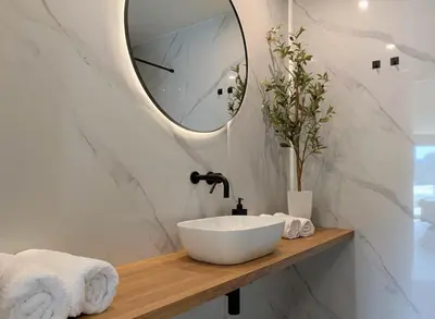 a bathroom with a white sink and a mirror at Green Heart Suites in Podljubelj