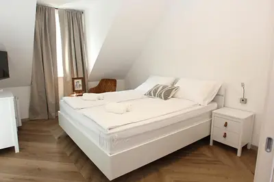 a large white bed in a white room at D Rooms in Ljubljana