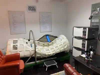 a hospital bed in a room with a chair at D Rooms in Ljubljana