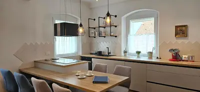 a kitchen with a table and a counter with chairs at Riva Residence in Old Town Ljubljana by the Cobblers' Bridge in Ljubljana