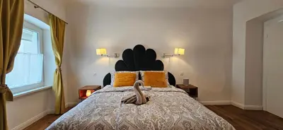 a bedroom with a large bed with a large headboard at Riva Residence in Old Town Ljubljana by the Cobblers' Bridge in Ljubljana