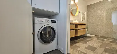 a white washer and dryer in a bathroom at Riva Residence in Old Town Ljubljana by the Cobblers' Bridge in Ljubljana