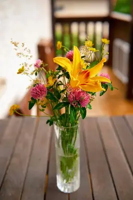a vase filled with yellow and pink flowers on a table at Apartma PR ČEHC in Tolmin
