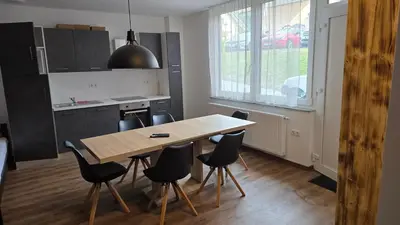 a kitchen with a wooden table and black chairs at Apartma Alja 4 Kranjska Gora in Kranjska Gora