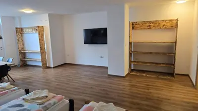 a room with wooden floors and a room with shelves at Apartma Alja 4 Kranjska Gora in Kranjska Gora
