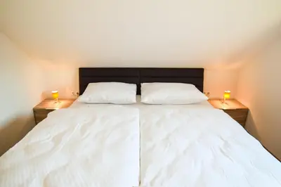 a bedroom with a large white bed with two lamps at Apartments Katja in Kranjska Gora
