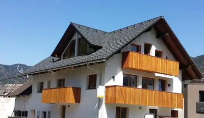a white building with wooden balconies on it at Apartments Katja in Kranjska Gora