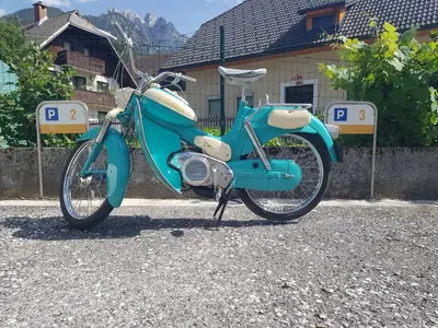 a blue motorcycle parked in front of a building at Apartments Katja in Kranjska Gora
