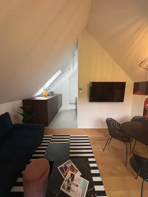 a living room with a couch and a tv at AvantGarden in Bled