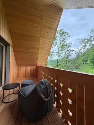 a room with a chair on a deck with a window at AvantGarden in Bled