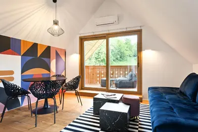 a living room with a couch and a table and chairs at AvantGarden in Bled