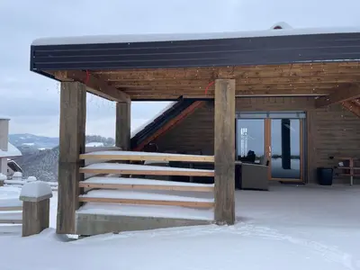 a wooden cabin with stairs in the snow at Zerko Holiday Apartment Janko with JACUZZI and SAUNA in Mirna