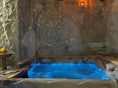 a jacuzzi tub in a room with a stone wall at Zerko Holiday Apartment Janko with JACUZZI and SAUNA in Mirna