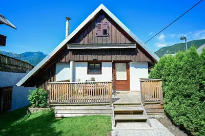 a small house with a wooden porch and a balcony at Apartma Špelca in Bohinj