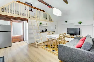 a living room with a couch and a kitchen with a loft at Apartma Špelca in Bohinj