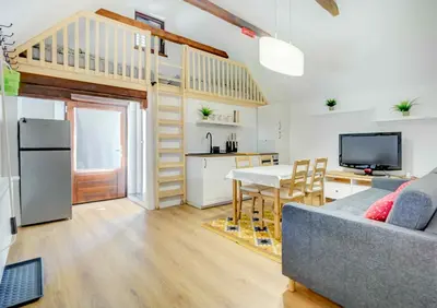 a living room with a couch and a table and a kitchen at Apartma Špelca in Bohinj