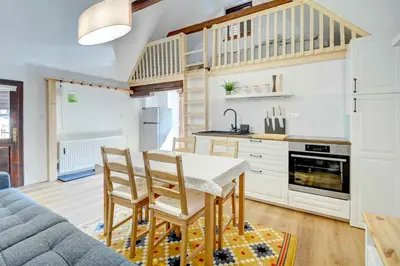 a kitchen with a table and chairs and a couch at Apartma Špelca in Bohinj