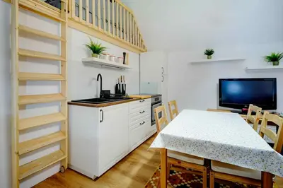 a kitchen with a table and a tv in a room at Apartma Špelca in Bohinj