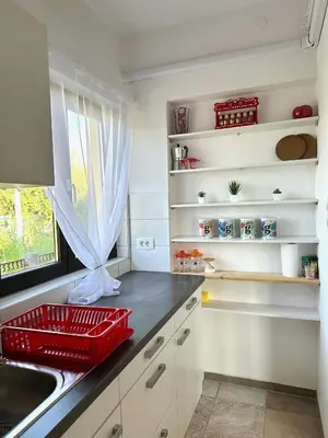 a kitchen with a red basket next to a sink at Adria Apartment in Spodnje Škofije