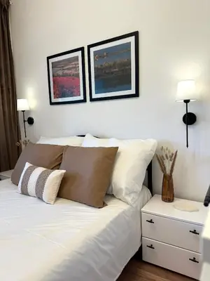 a bedroom with a white bed with two pictures on the wall at Adria Apartment in Spodnje Škofije