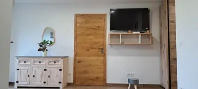a room with a door and a television and a cabinet at Apartmaji Božiček in Podčetrtek
