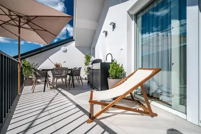 a balcony with a table and chairs and an umbrella at Strato Apartment in Kočevje
