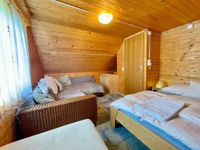a bedroom with two beds in a wooden cabin at Vacation cottage house Enya in Koprivnik v Bohinju