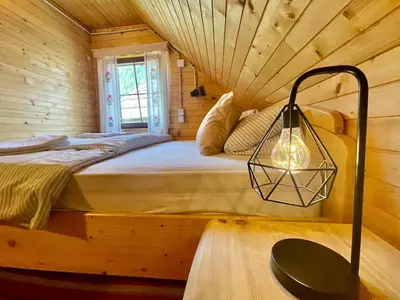 a bedroom with a bed in a log cabin at Vacation cottage house Enya in Koprivnik v Bohinju