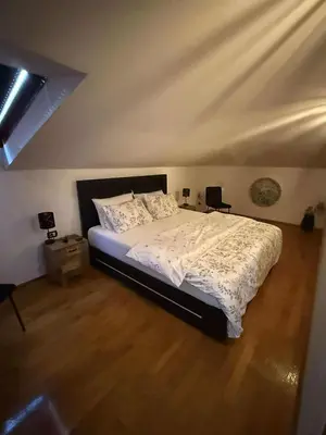 a bedroom with a bed and a wooden floor at Apartma Morizna in Kobarid