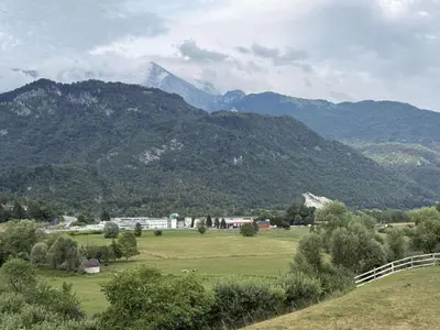 a view of a field with mountains in the background at Apartma Morizna in Kobarid