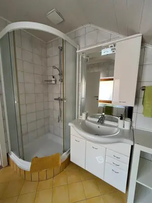 a bathroom with a shower and a sink and a tub at Apartma Mohorič in Idrija