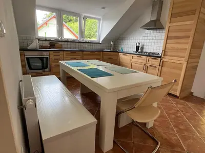 a kitchen with a white table and a chair at Apartma Mohorič in Idrija