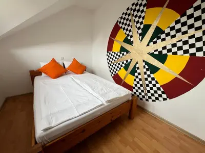 a bedroom with a bed with a painting on the wall at Apartma Mohorič in Idrija