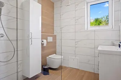 a bathroom with a toilet and a sink and a window at Hiša PolajnArh in Bohinj