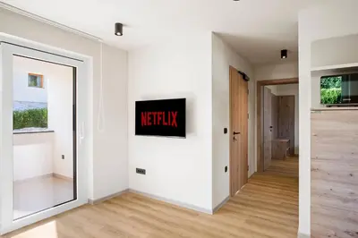 a hallway with white walls and a large mirror at Hiša PolajnArh in Bohinj