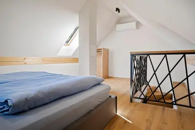 a bedroom with a bed and a staircase at Hiša PolajnArh in Bohinj