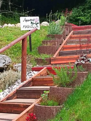 a garden with wooden steps with a sign on it at Apartment Magnolia in Blejska Dobrava