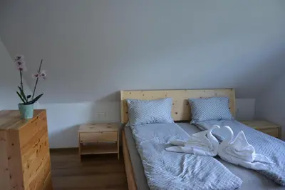 a bedroom with two beds with blue sheets and a nightstand at Apartma Rebeka in Zgornje Gorje