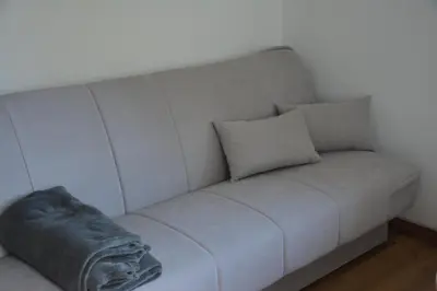 a couch with two pillows and a blanket on it at Apartma Rebeka in Zgornje Gorje
