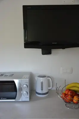 a kitchen counter with a microwave and a bowl of fruit at Apartma Rebeka in Zgornje Gorje