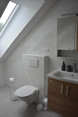 a white bathroom with a toilet and a sink at Apartma Rebeka in Zgornje Gorje