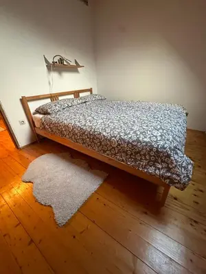 a bed in a room with a rug on the floor at Pinus Alpinus Apartments in Bovec