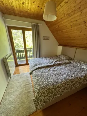 a bedroom with a bed and a large window at Pinus Alpinus Apartments in Bovec