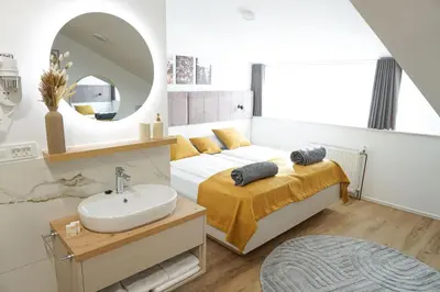 a bedroom with a bed with a sink and a mirror at Gostisce Ulipi in Slovenske Konjice