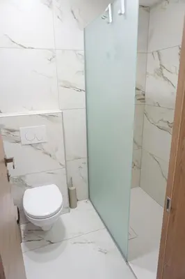a white bathroom with a toilet and a shower at Gostisce Ulipi in Slovenske Konjice