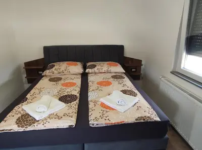 a bedroom with a bed with two towels on it at Družinski apartmaji Judnič in Adlešiči